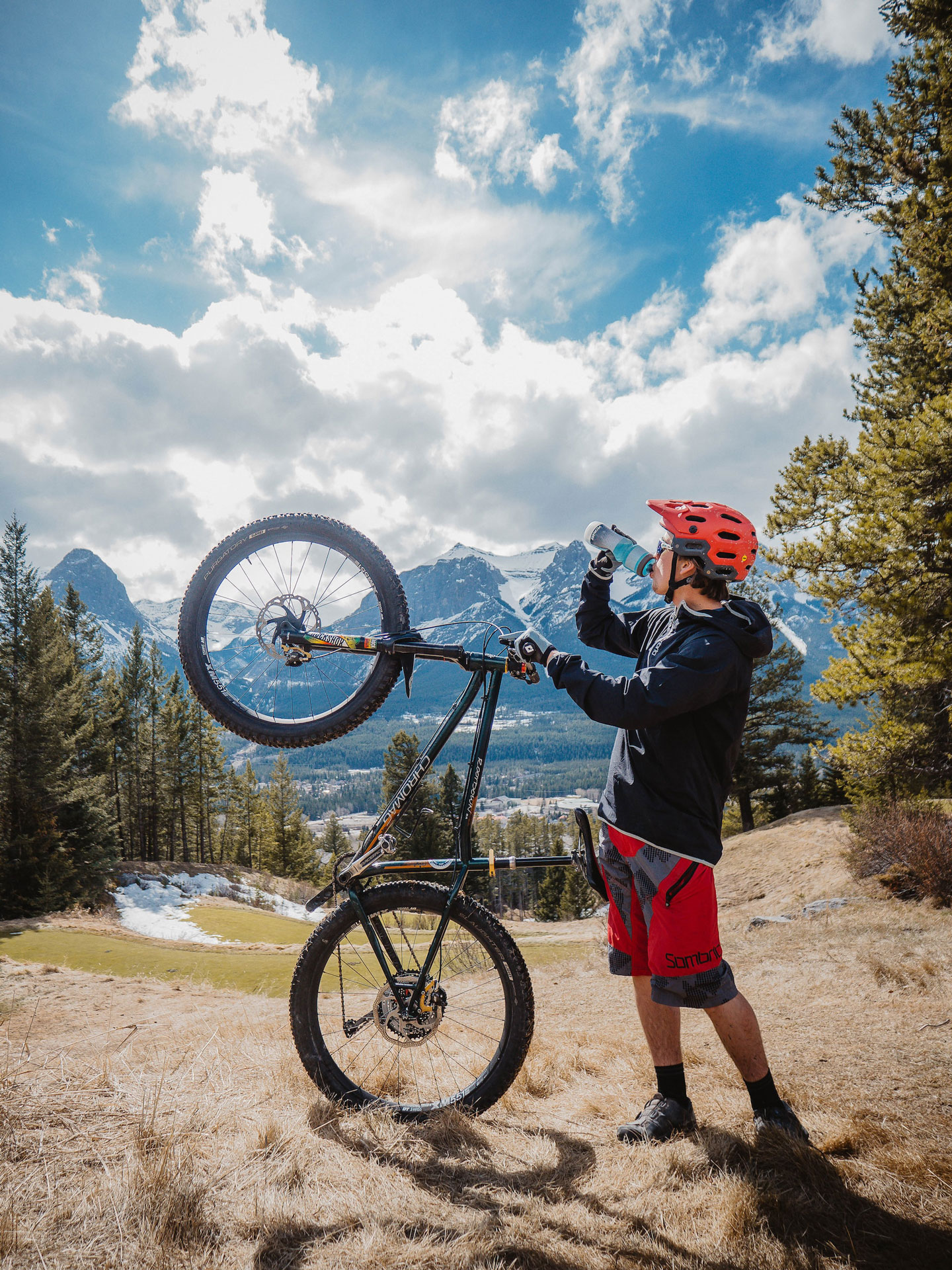 picutre of man holding bike and drinking water